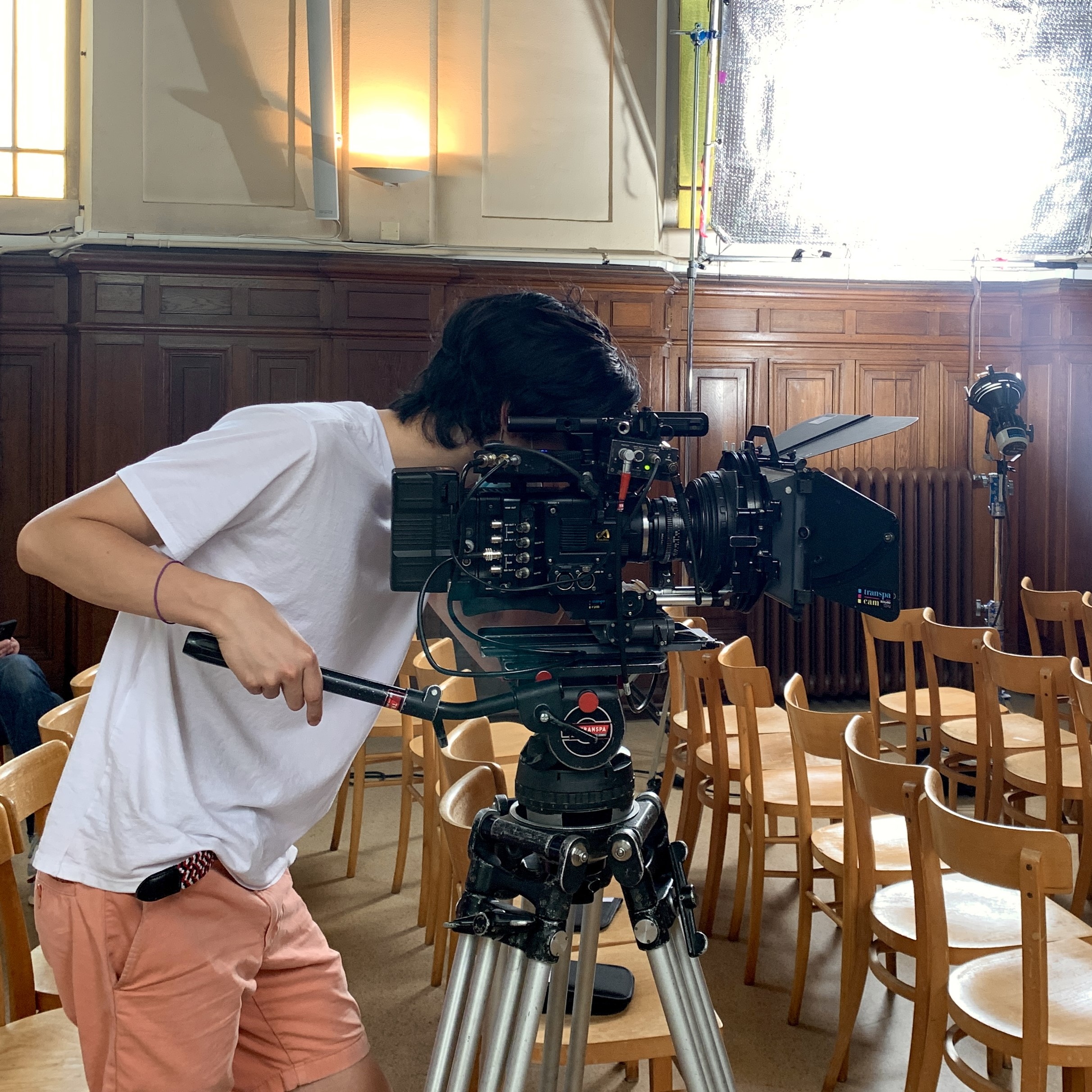 Jake Wong operating a professional cinema camera on a tripod during a shoot.